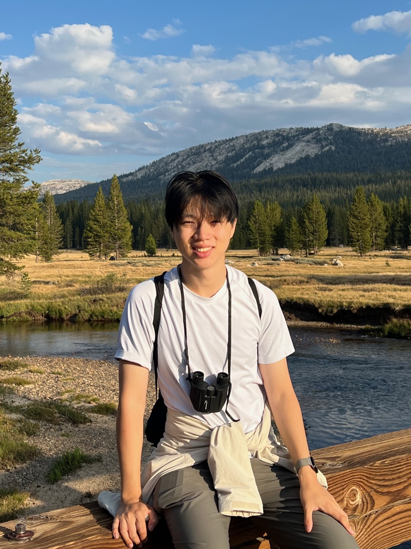 Shaun sitting on a wooden footbridge in Tuolumne Meadows, Yosemite